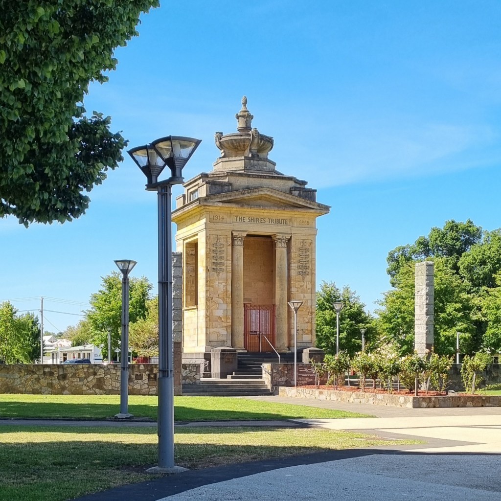 picture of a yellow building in a park with a lamppost in front