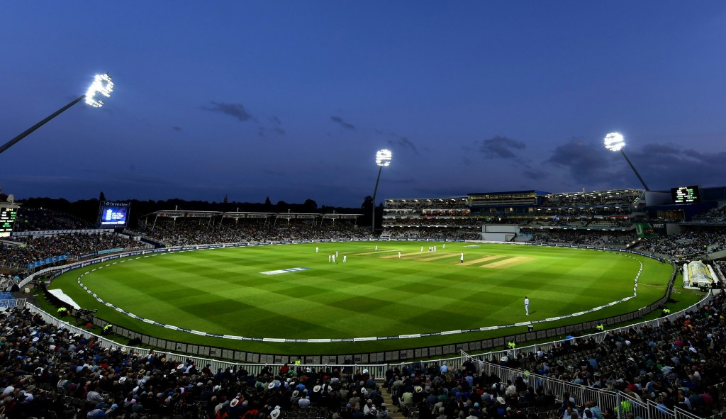 A cricket stadium at night showing players on the field